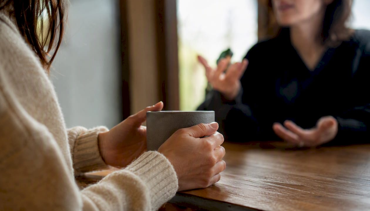 Close-up of hands holding coffee mug during listening