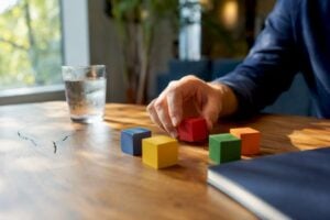 Hands arranging sales coaching blocks