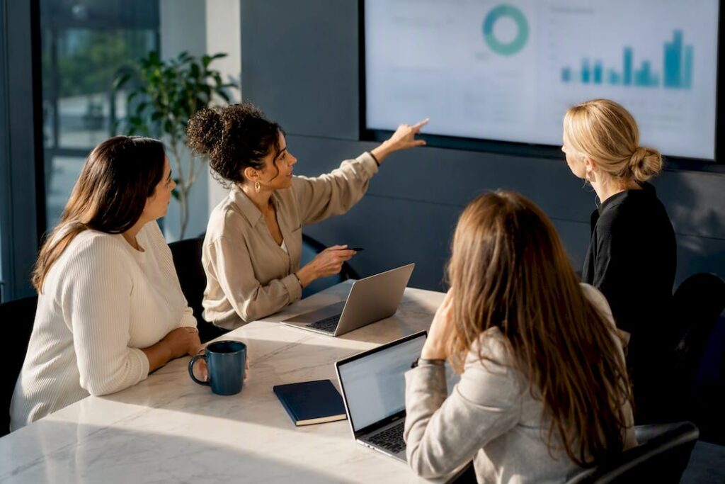 Women reviewing a sales leadership cohort project